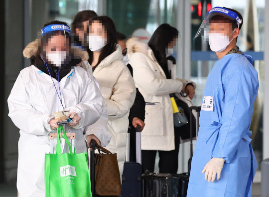 중국발 한국행 항공기에 탑승하는 모든 내·외국인의 코로나19 음성확인서 제출 의무화 첫날인 5일 오전 인천국제공항 제1여객터미널 입국장에 중국발 항공기 탑승자들이 방역 관계자들의 안내를 받으며 이동하고 있다.   연합뉴스